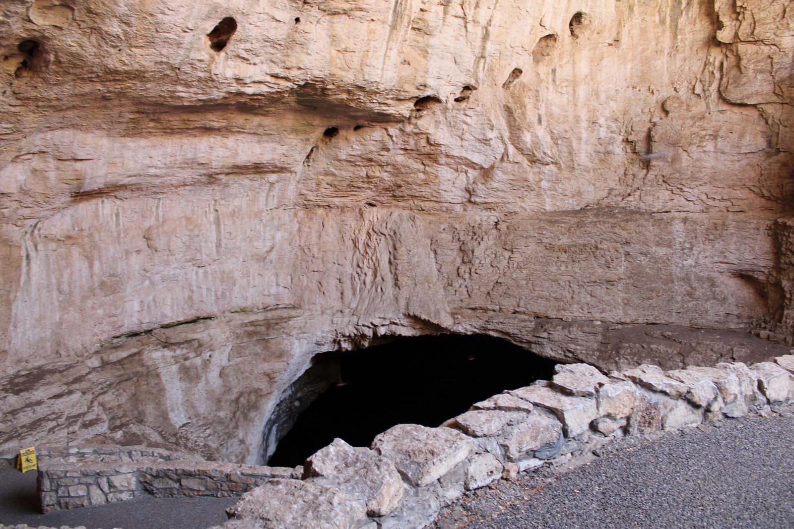 Close-up view looking down into the giant, rocky opening of the Natural Entrance at Carlsbad Caverns.