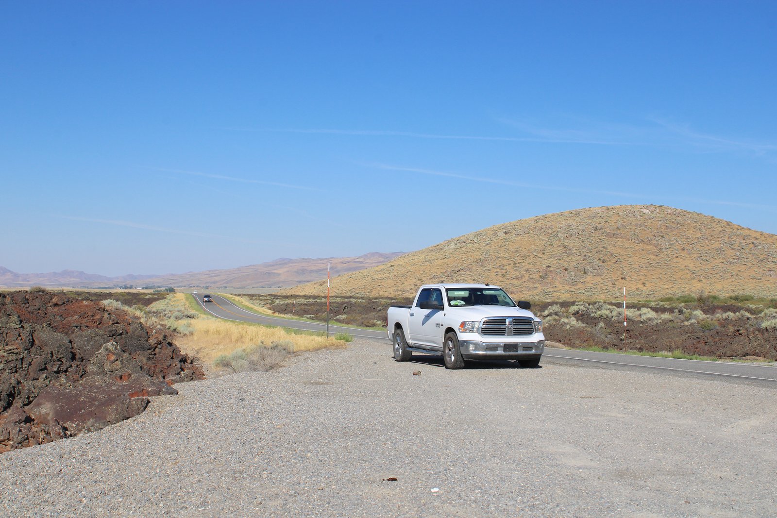 Pickup truck driving along the open highway toward Craters of the Moon National Monument in central Idaho