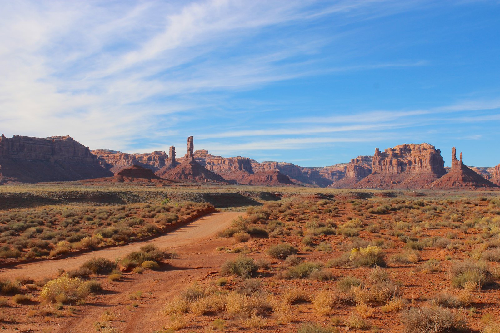 dirt road with red rocks in the distance