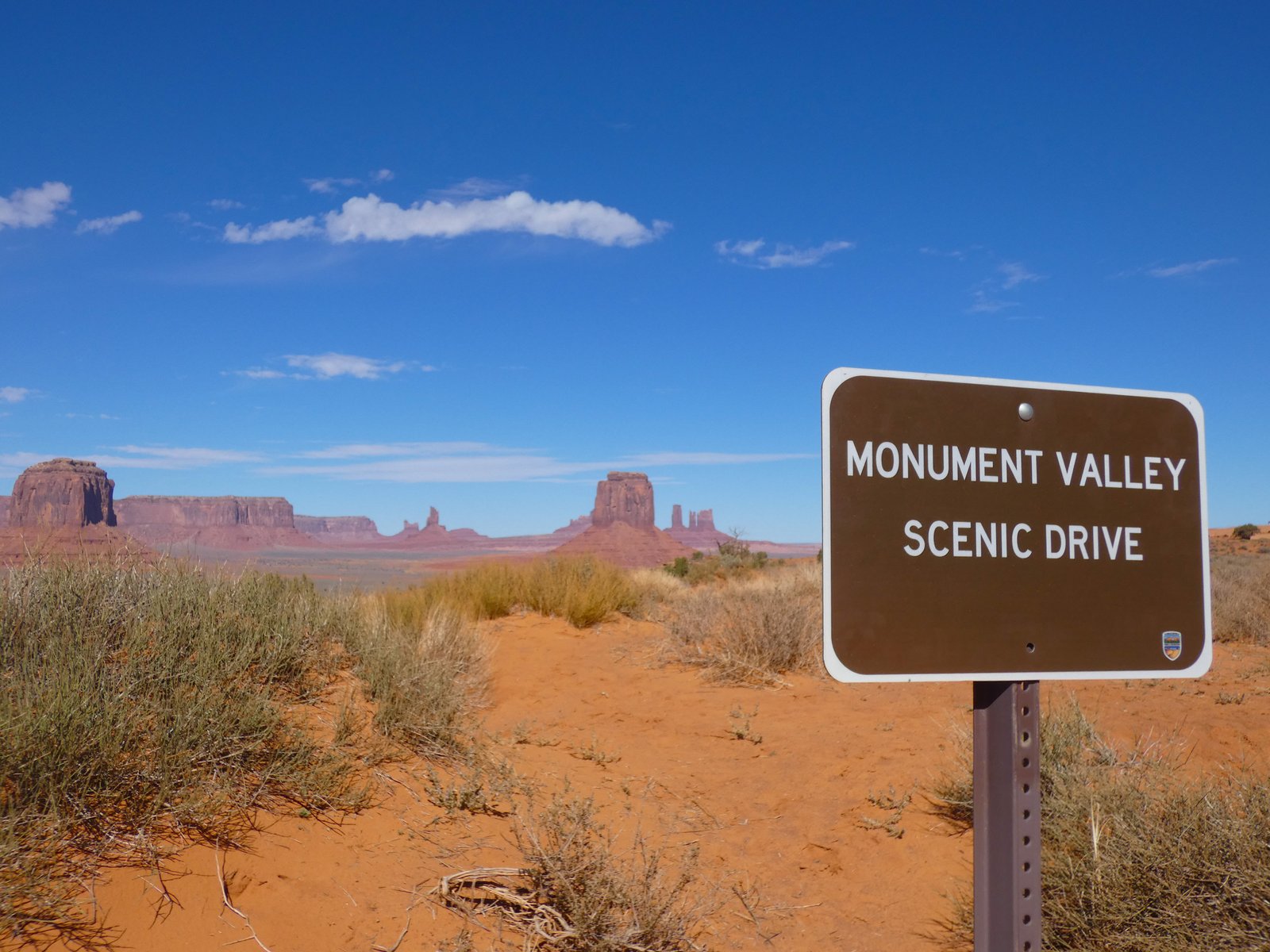 sign with red rocks in the distance