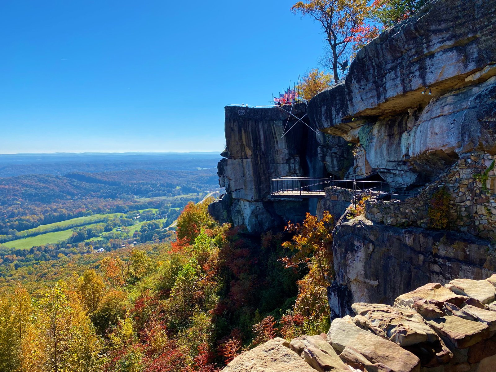 photo of rocky ledge overlooking rolling hills with fall colors