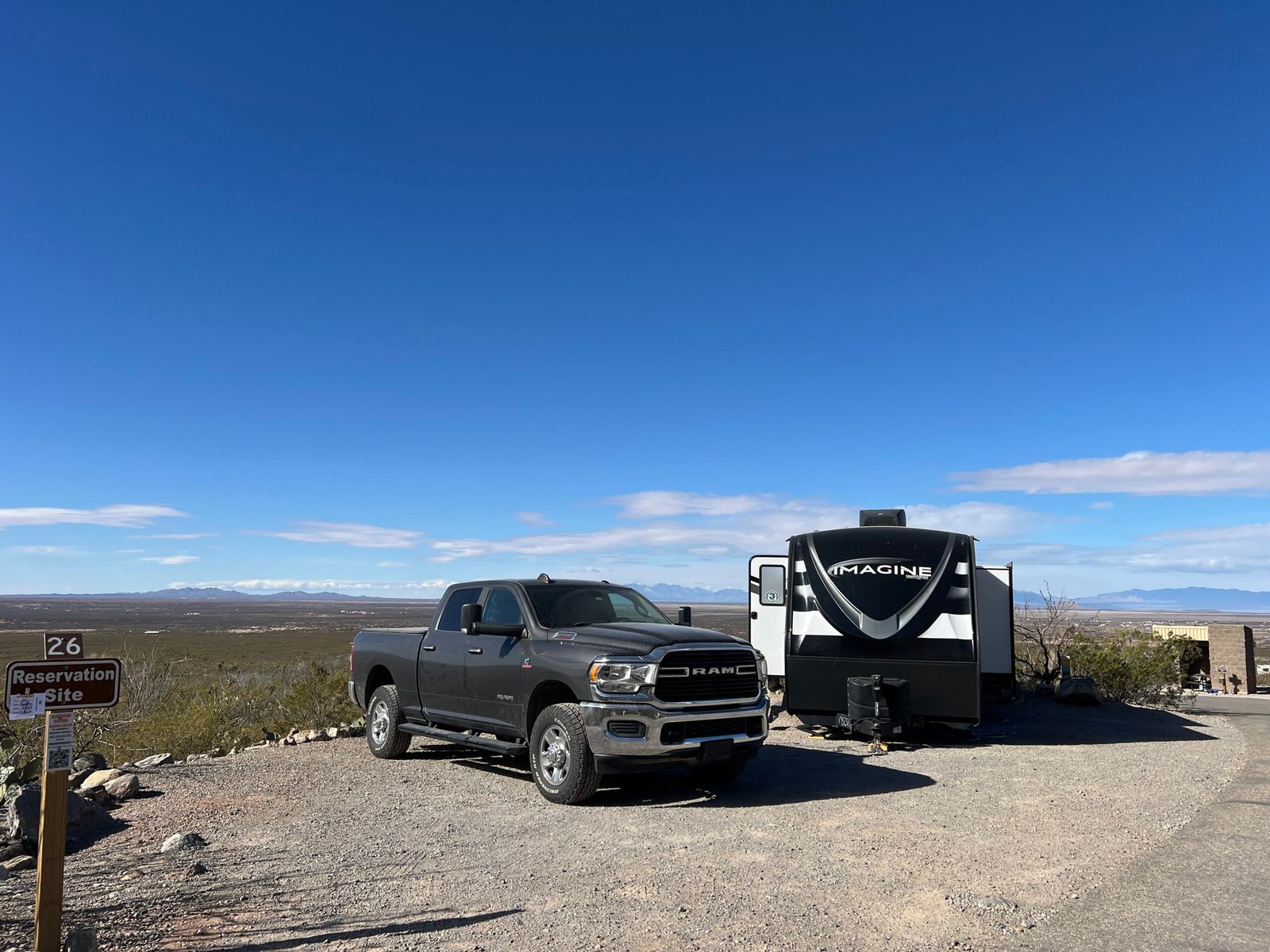 A pickup truck and travel trailer set up at a desert campsite with mountain views at Oliver Lee Memorial State Park near White Sands National Park in New Mexico.