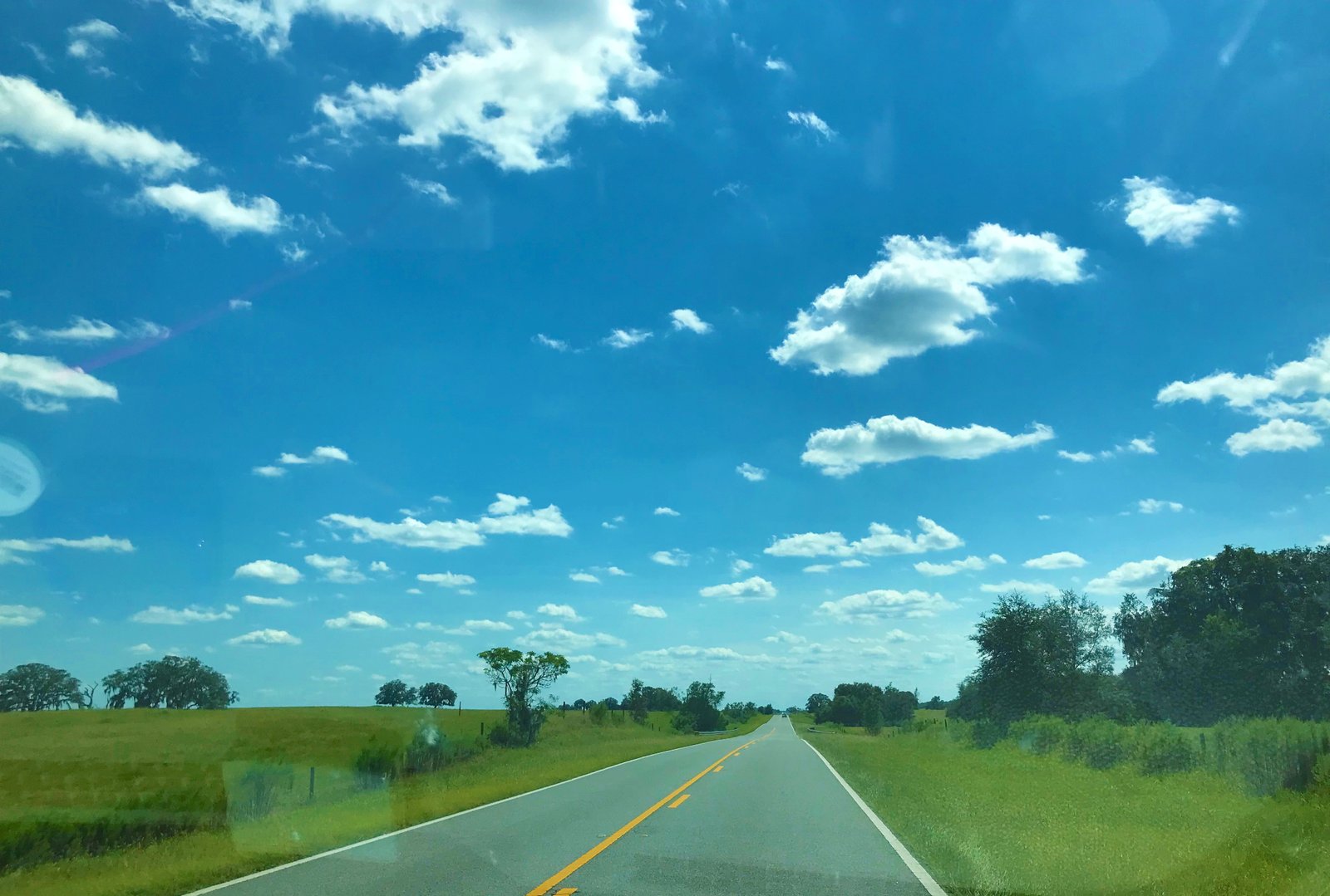 Quiet scenic road with rolling green hills and hay bales near the Rainbow Springs State Park campground in Dunnellon, Florida.