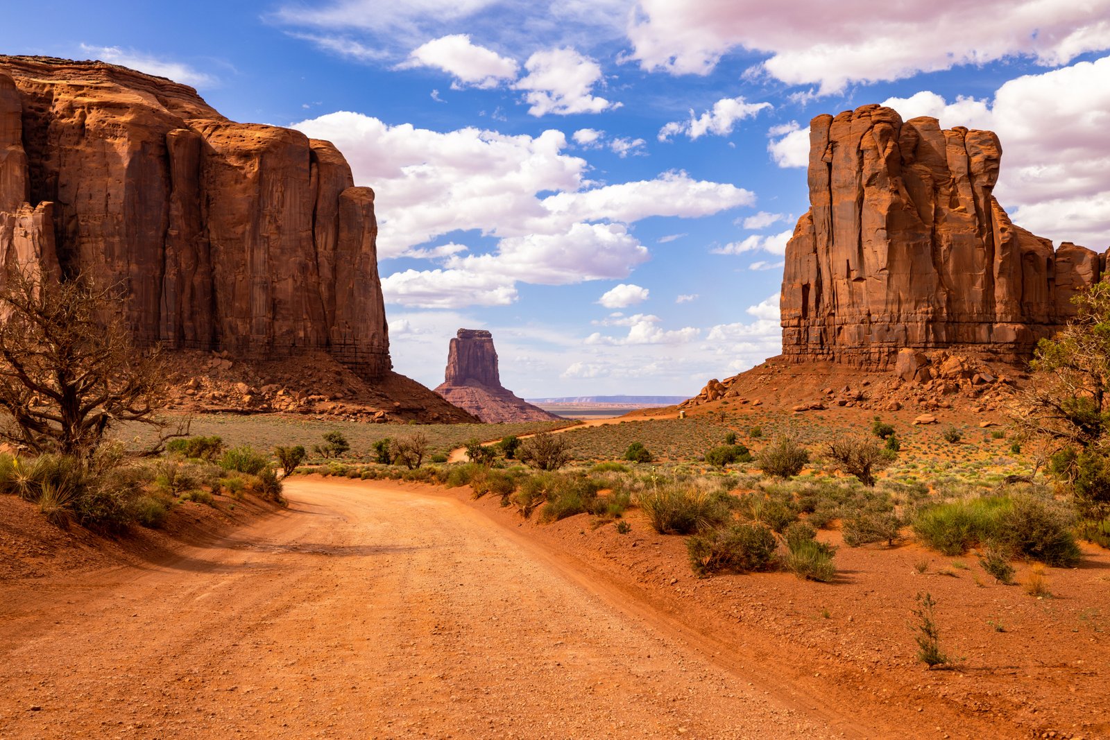 dirt road with towering red rocks around