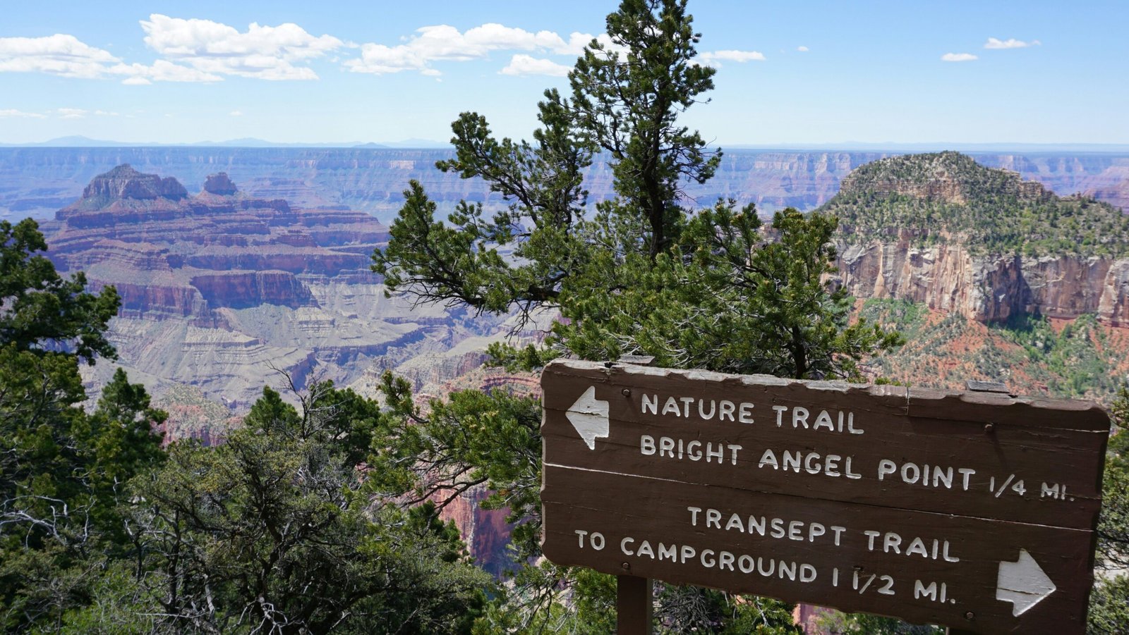 photo of trail sign with Grand Canyon in the distance