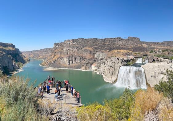 Wide angle view of the massive Shoshone Falls with visitors looking out from the lower viewing area, Idaho.