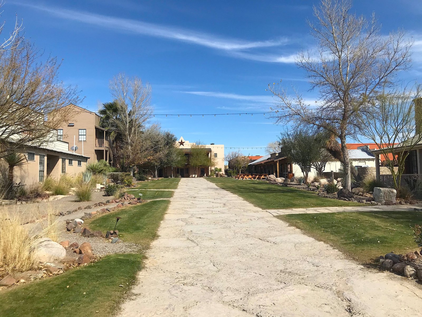 Wooden boardwalk path leading through southwestern resort buildings and desert landscaping at Lajitas Golf Resort.