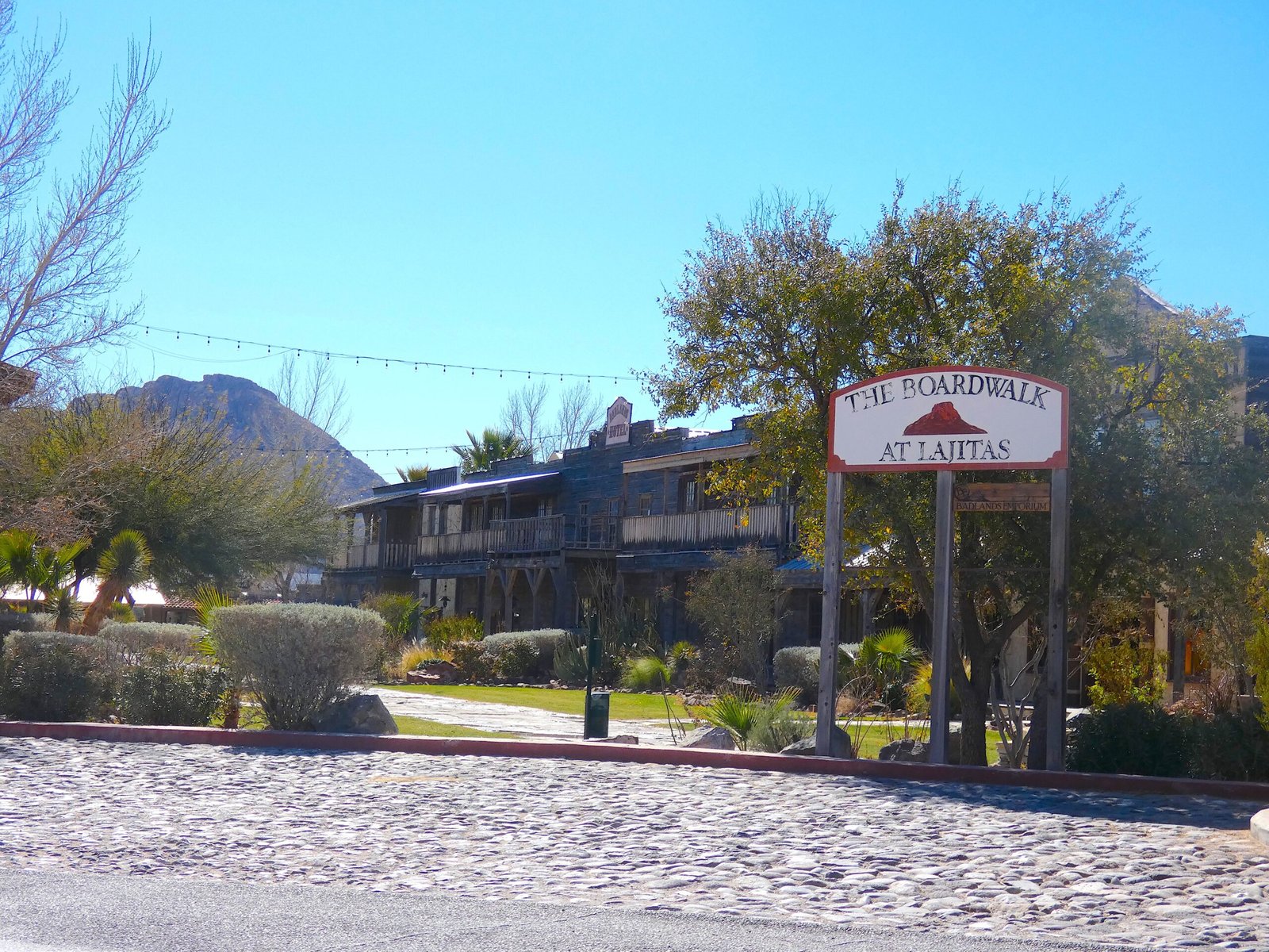 Lajitas Golf Resort wooden sign and boardwalk leading to southwestern-style resort buildings in the West Texas desert.