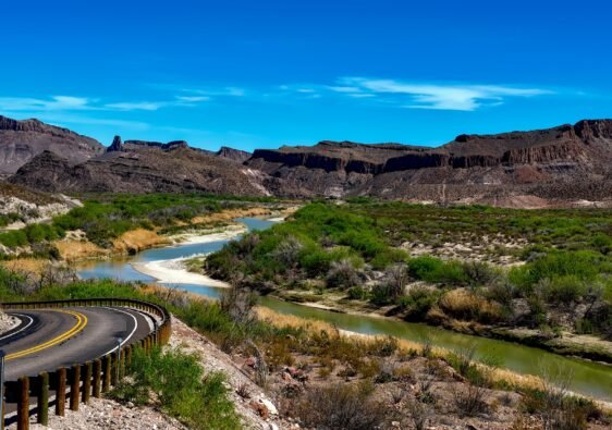 Winding asphalt pavement of FM 170 River Road hugging the Rio Grande in Big Bend Ranch State Park Texas.