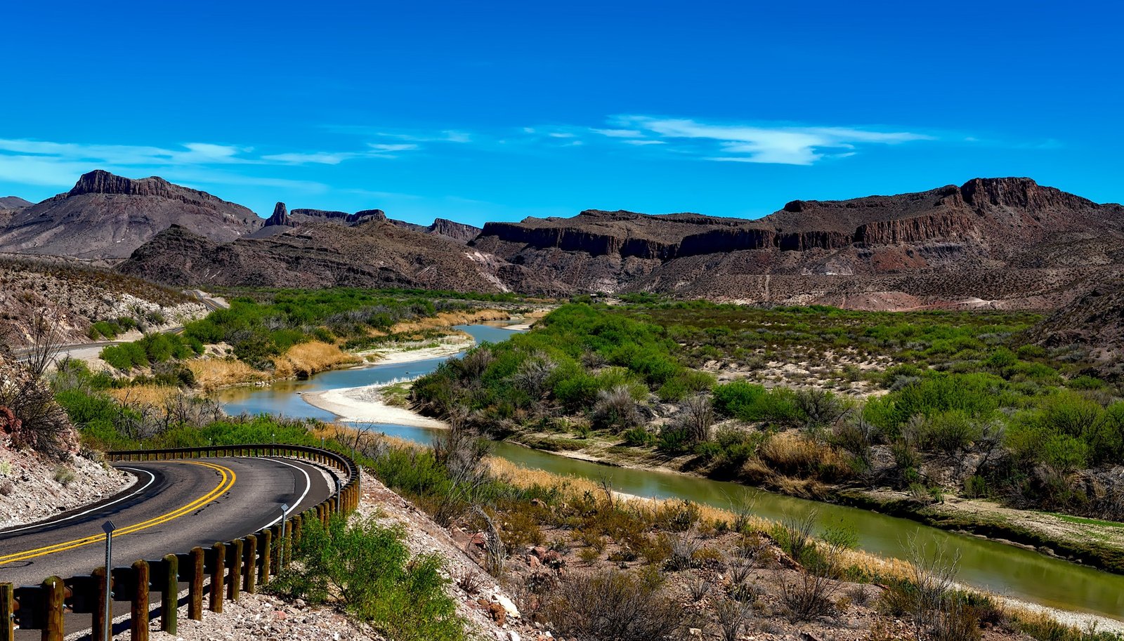Winding asphalt pavement of FM 170 River Road hugging the Rio Grande in Big Bend Ranch State Park Texas.
