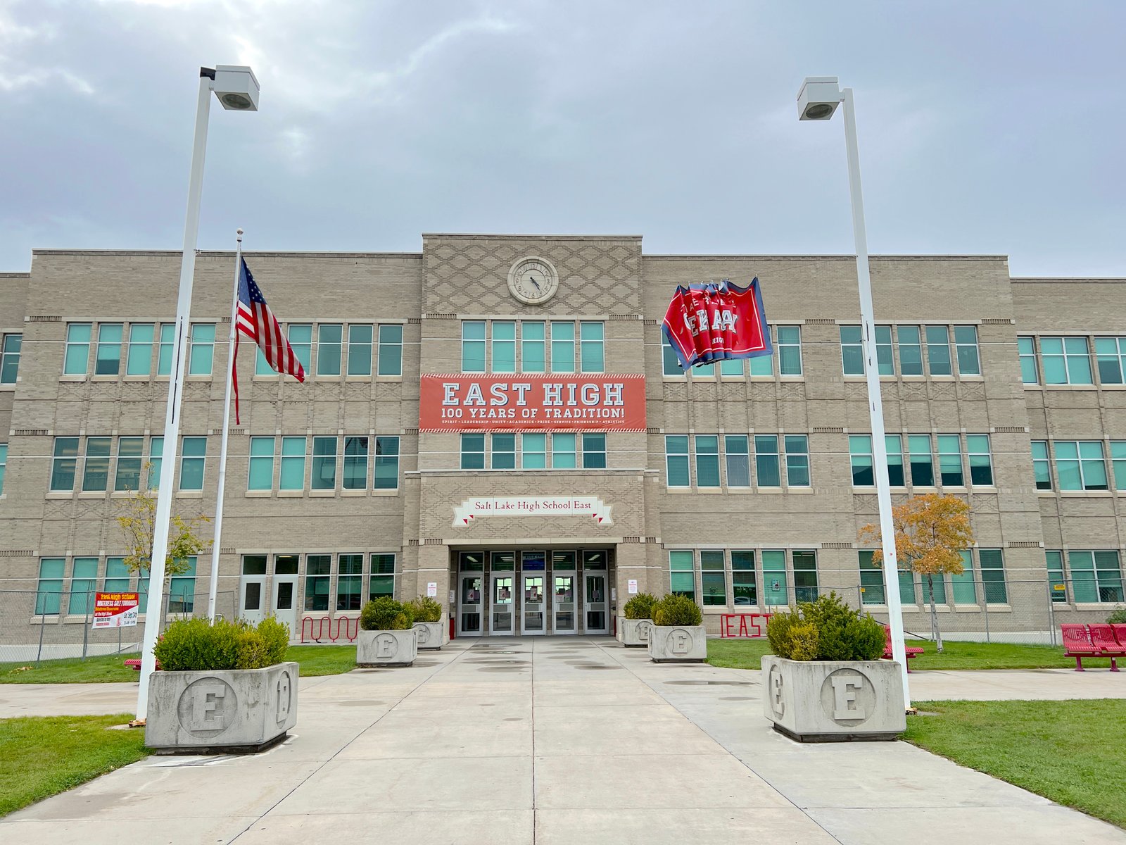 A wide front exterior view of the historic brick facade and large windows at East High School in Salt Lake City.