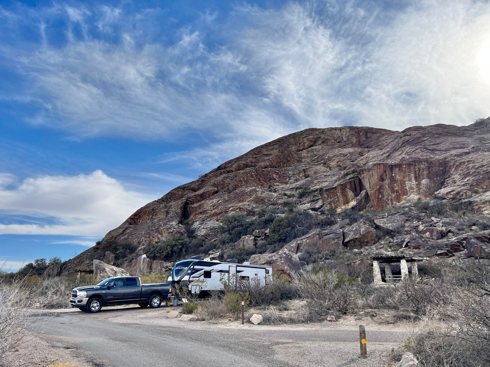 Truck and travel trailer set up at a scenic desert campsite surrounded by giant rock boulders at Hueco Tanks State Park.