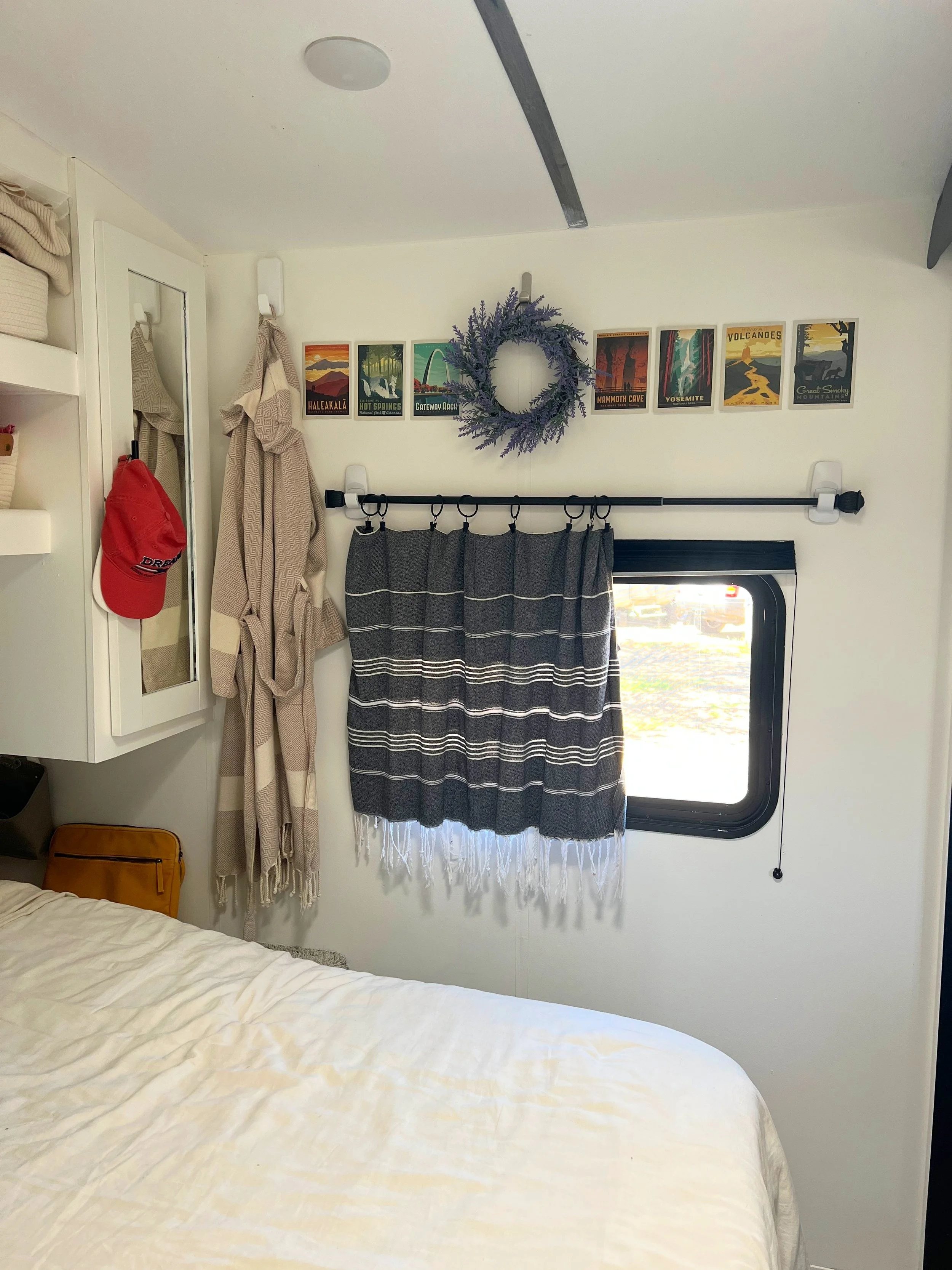A fully installed no-sew Turkish towel curtain hanging neatly over a camper window using a black rod and Command hooks.