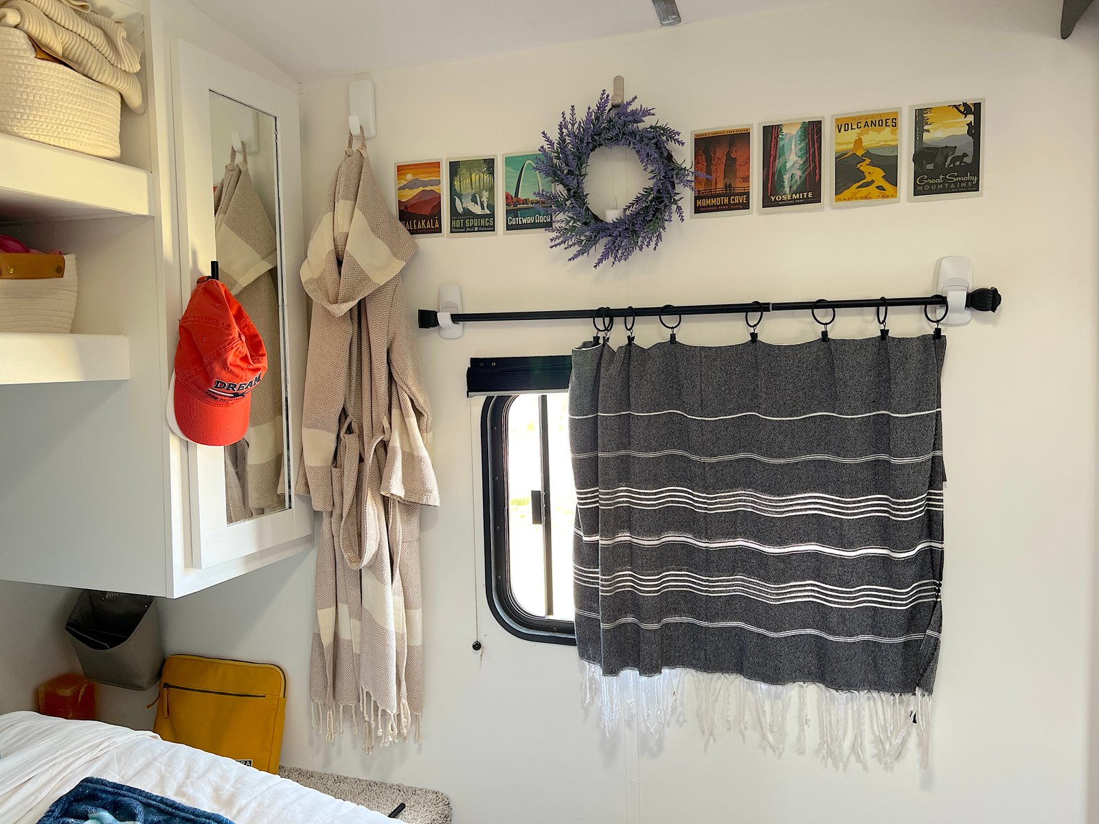 Close-up of a stylish no-sew RV curtain made from a patterned Turkish towel hung with a black rod and Command hooks on a camper wall.