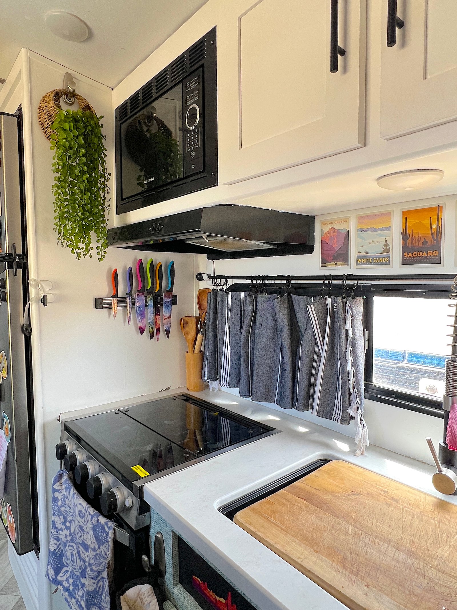 A long rectangular kitchen window in an RV styled with a no-sew Turkish towel curtain hung on a black rod using Command hooks