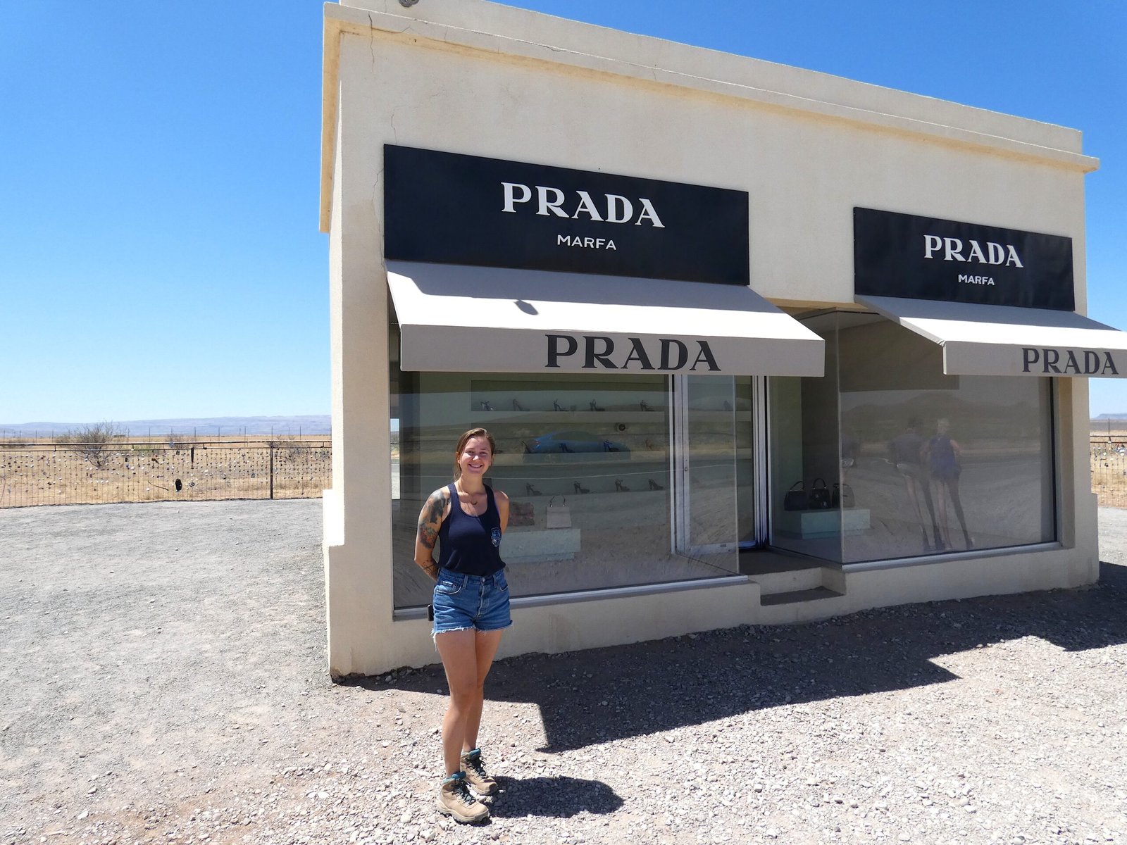 Traveler standing in front of the iconic Prada Marfa art installation along Highway 90 in West Texas.