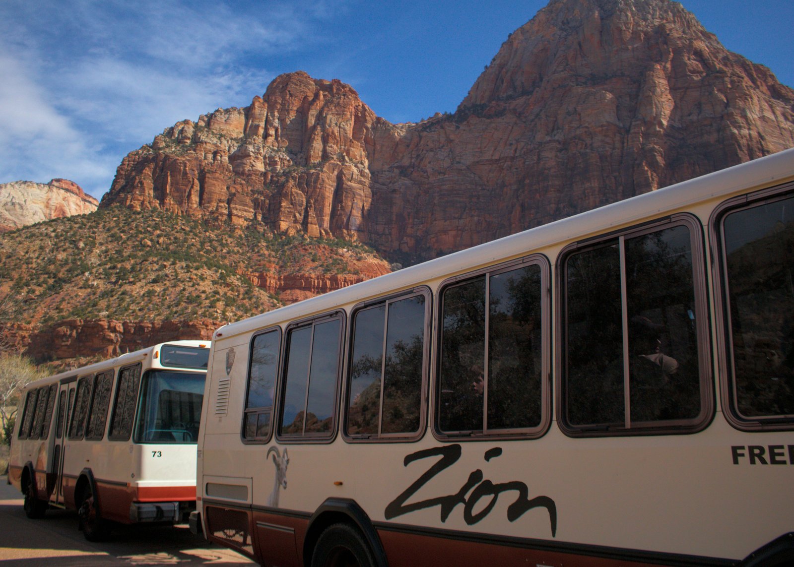 The Zion Canyon Shuttle driving past red rock canyon walls on the way to the Temple of Sinawava trailhead.