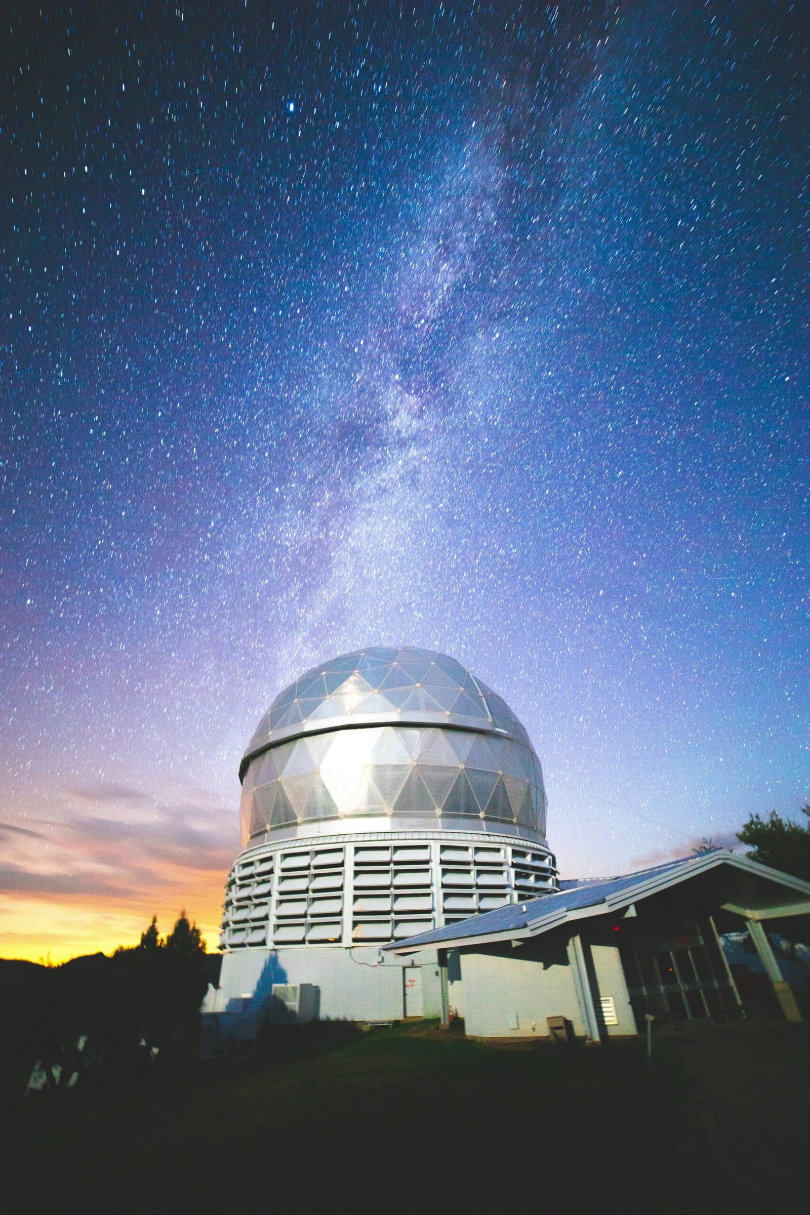 Large astronomical telescope dome structure at McDonald Observatory in Fort Davis under a starry night sky with the Milky Way.