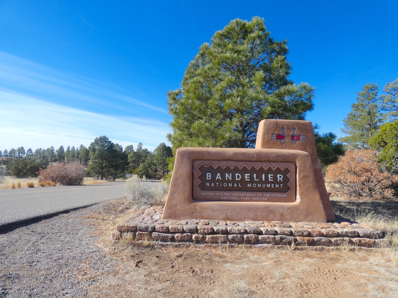 The wooden entrance sign for Bandelier National Monument welcoming visitors in New Mexico.