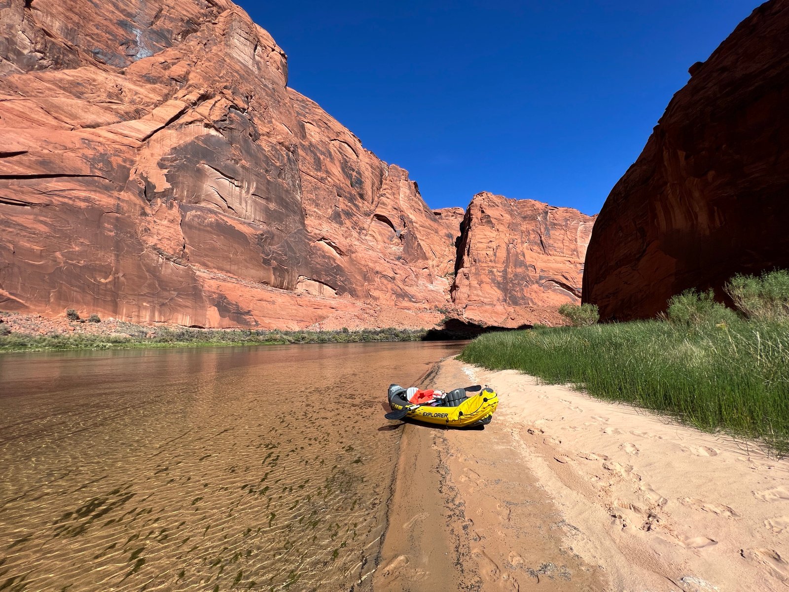 kayak on shoreline with red canyon walls behind