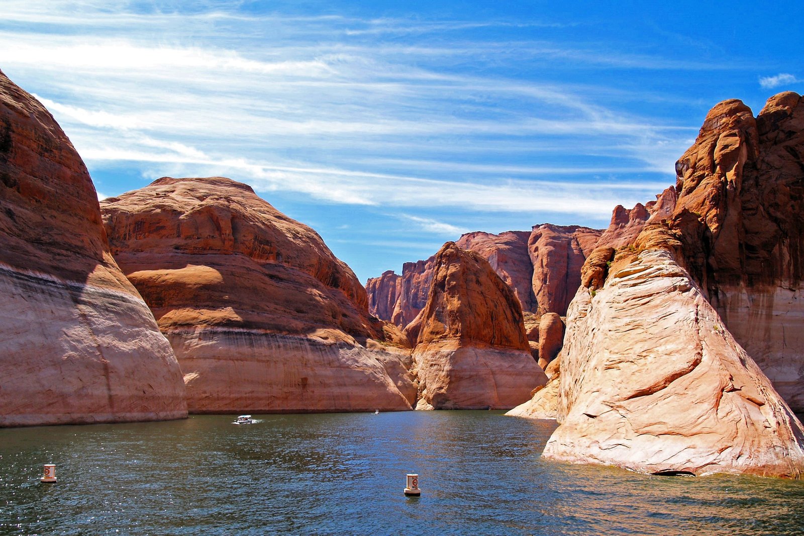 photo of river with towering red rock canyon walls below a blue sky