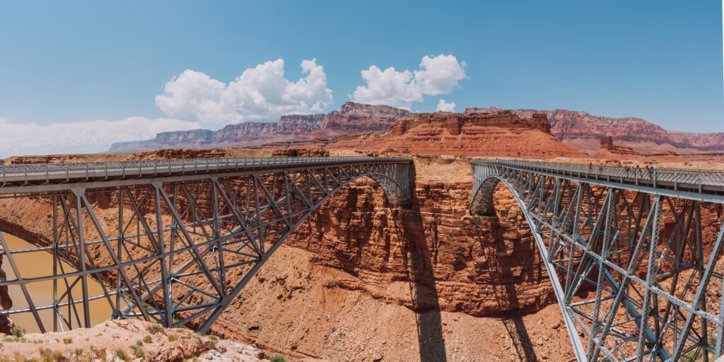 photo of two steel bridges side by side over canyon with red rocks