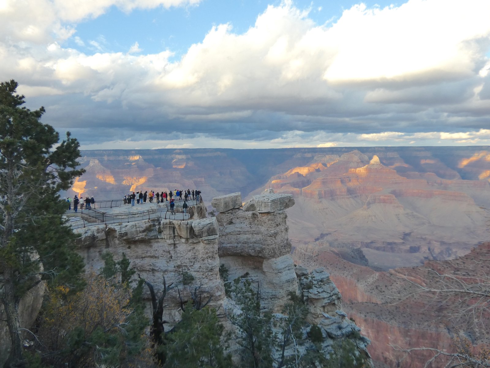 view of people at an overlook near the edge of the Grand Canyon
