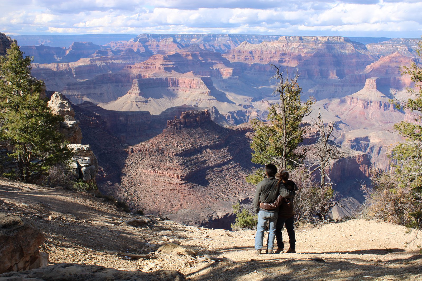 two people standing together looking out at the Grand Canyon
