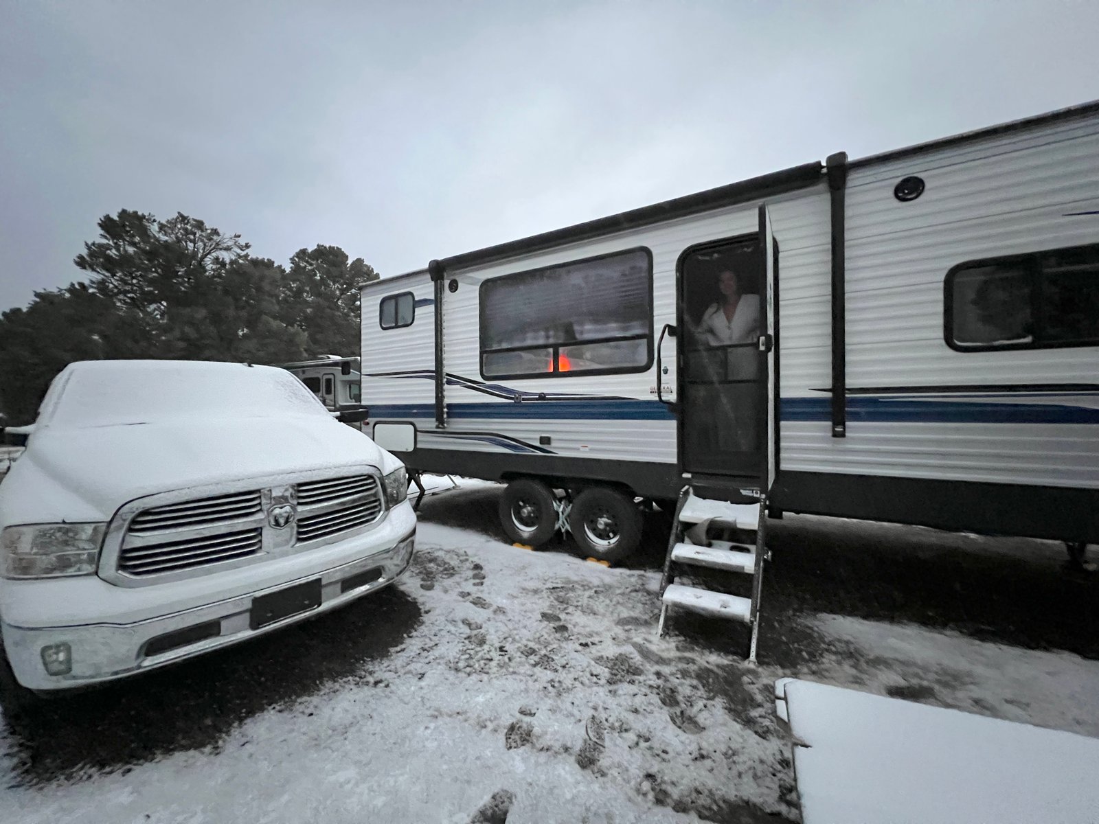 photo of rv and truck at campsite covered in snow