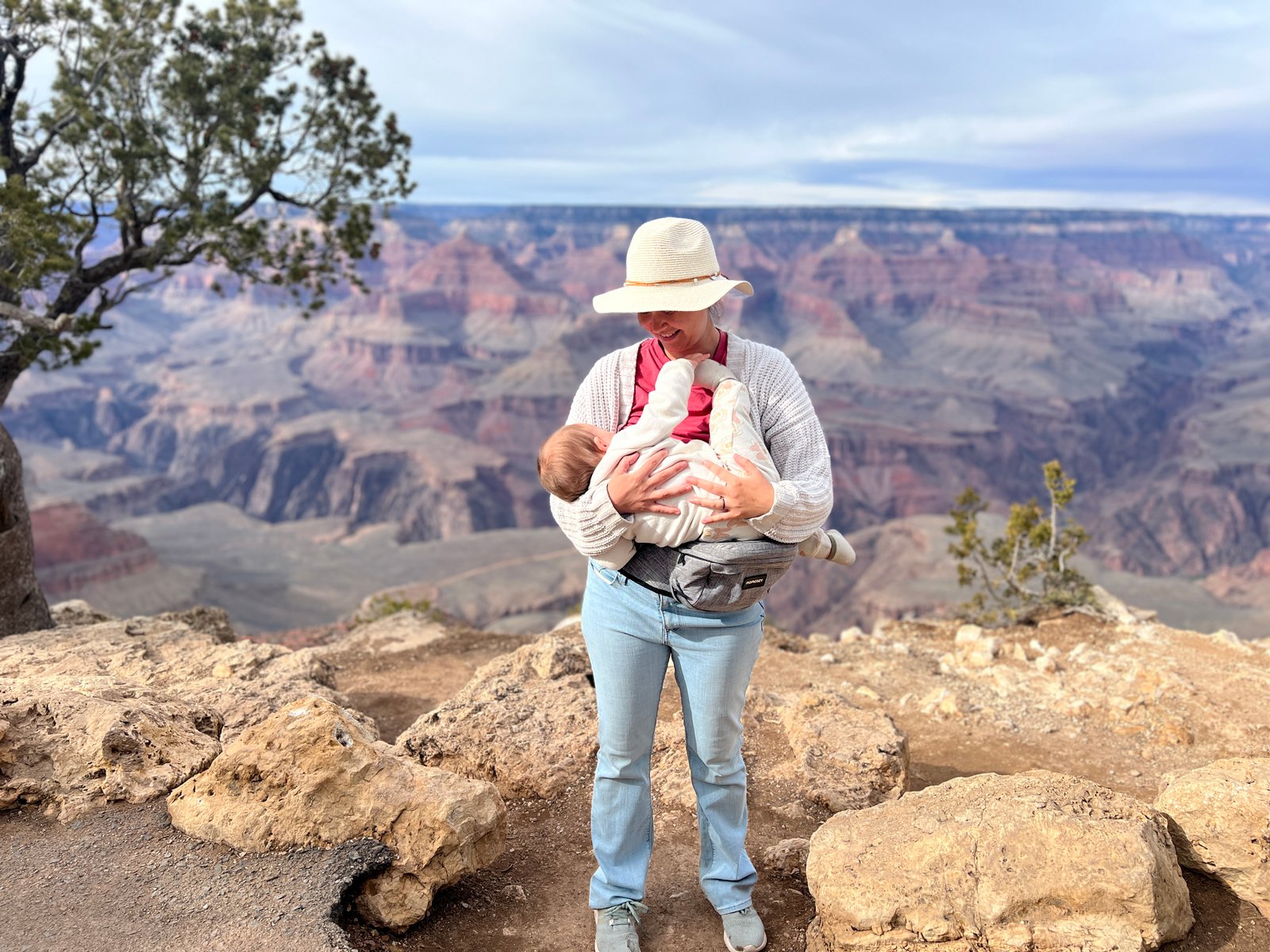 woman holding baby with Grand Canyon behind