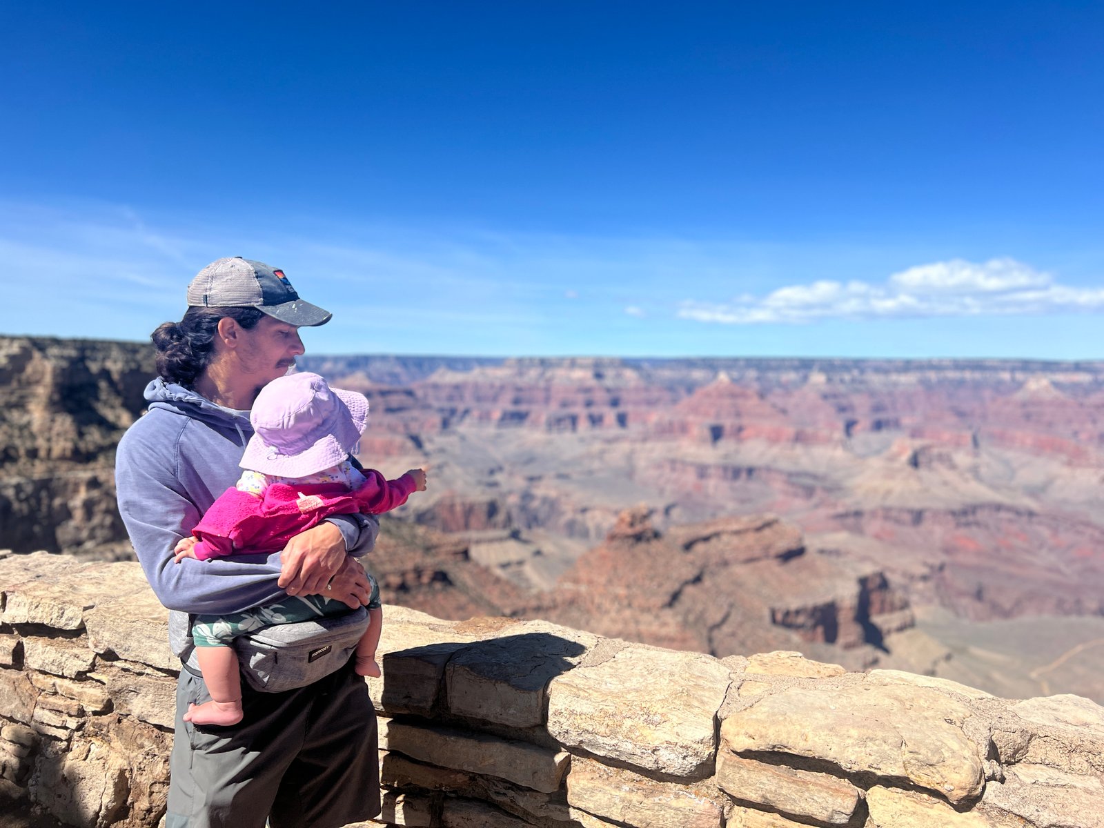 man holding baby at an overlook of the Grand Canyon