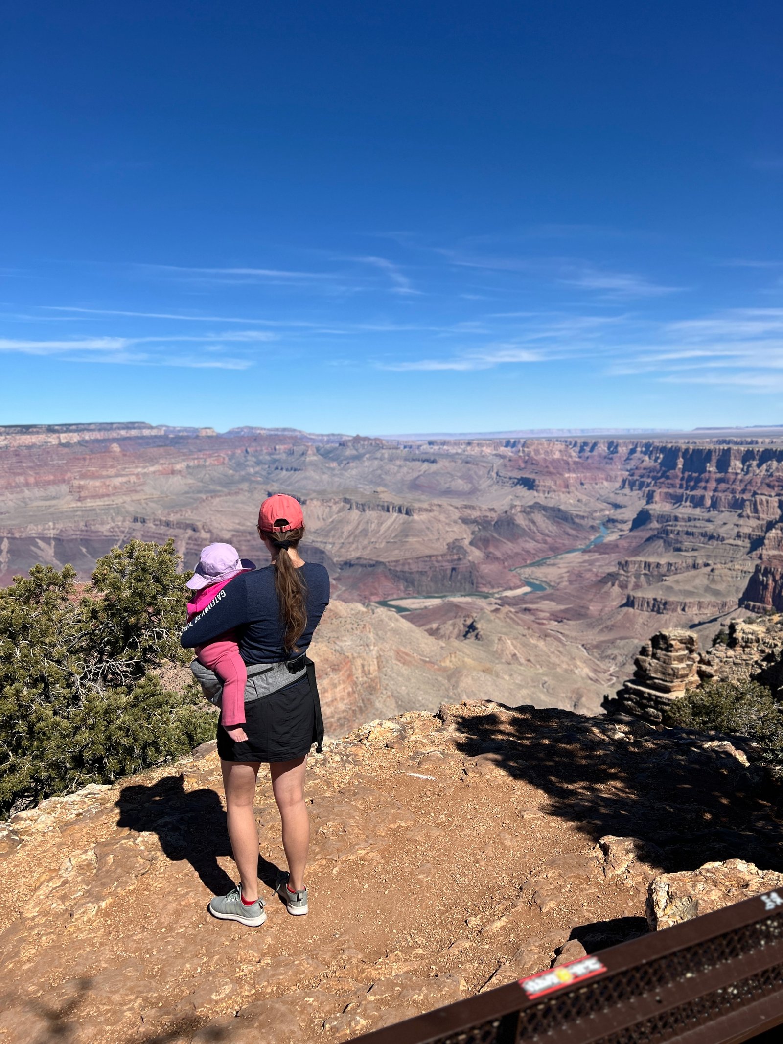 woman holding baby looking out at the Grand Canyon